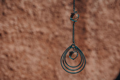 Close-up of pendant hanging against textured wall