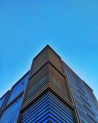 Low angle view of modern building against clear blue sky