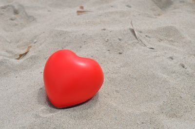 Close-up of heart shaped balloon on sand