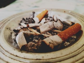 Close-up of cigarette butts in ashtray