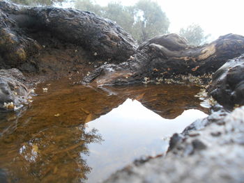 Reflection of rock formation in lake against sky