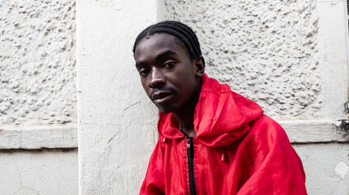 Portrait of young man standing against wall