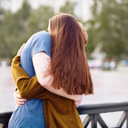 Rear view of women standing on railing