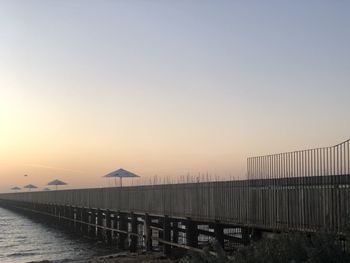 Scenic view of bridge against clear sky during sunset