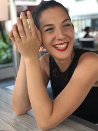 Portrait of a smiling young woman sitting on table