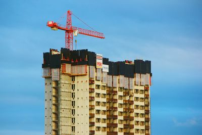 Low angle view of crane against sky