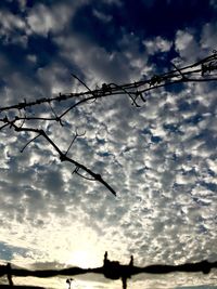 Cloudy sky seen through chainlink fence