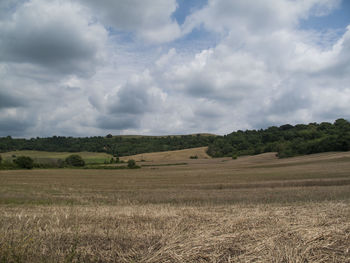 Scenic view of field against cloudy sky
