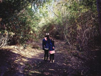 Rear view of women walking in forest