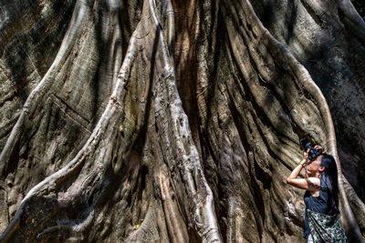 Full length of woman holding tree trunk rock