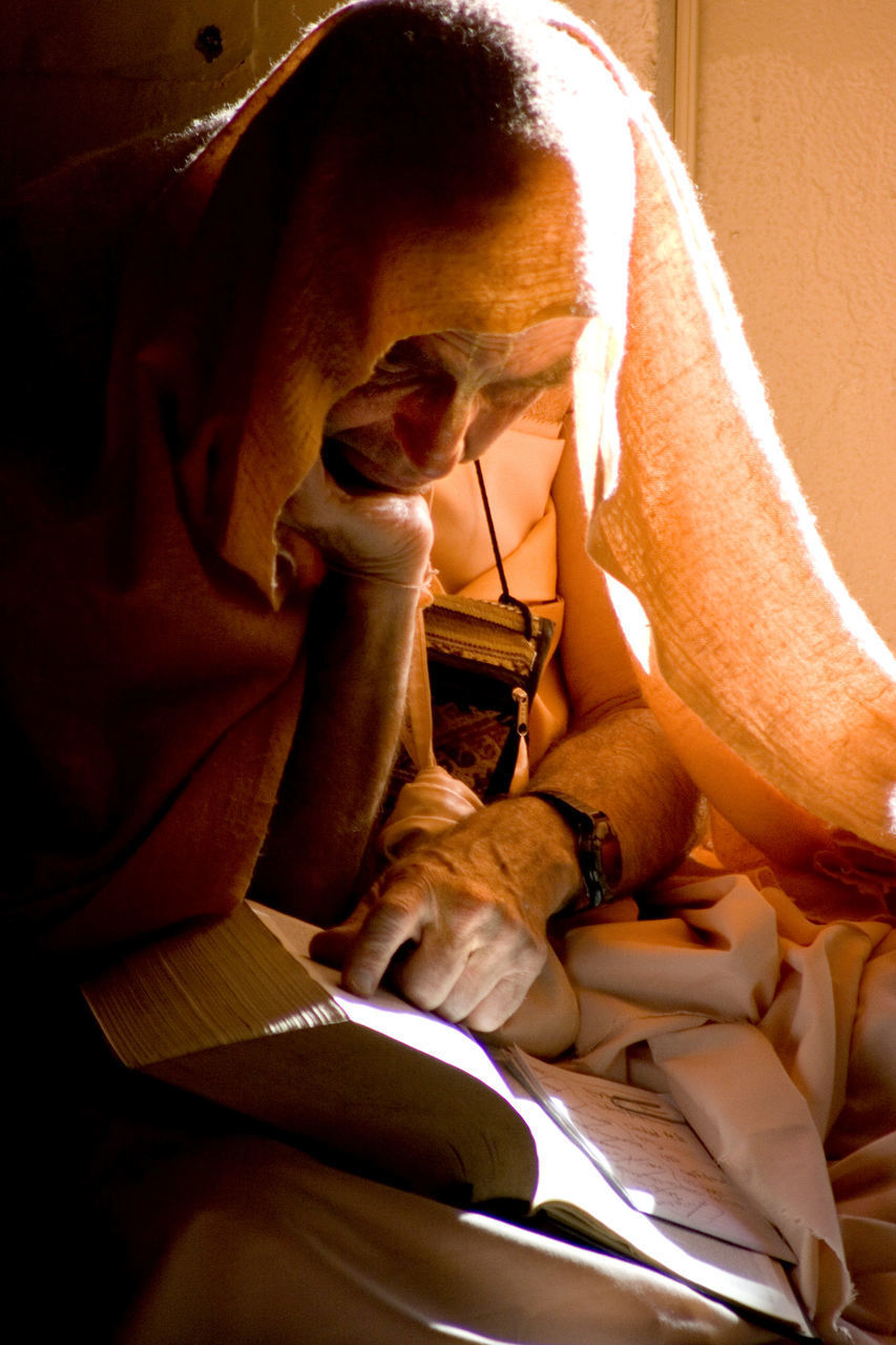 MIDSECTION OF MAN SITTING ON BED