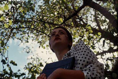 Low angle view of woman against tree