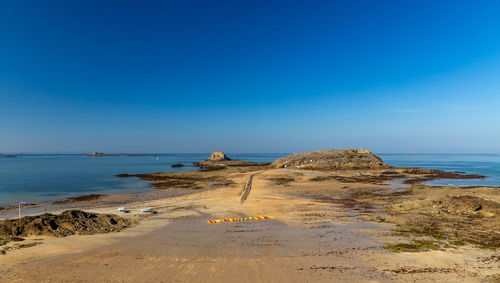 Scenic view of beach against clear blue sky