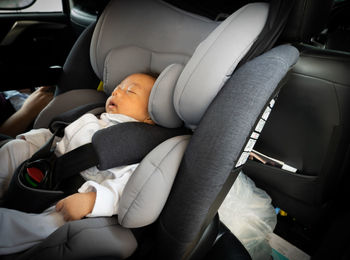 Close-up, the baby is sitting on his car seat.