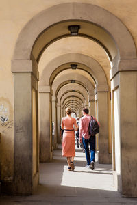 Rear view of women walking in corridor of building