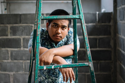 Portrait of teenage boy sitting in building