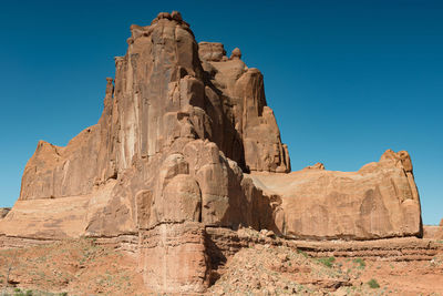 Low angle view of rocky mountains against blue sky