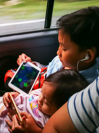 Portrait of woman holding mobile phone while sitting in bus