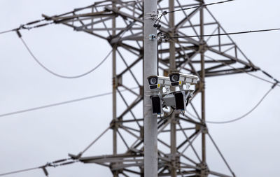 Low angle view of electricity pylon against sky