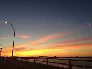 Scenic view of silhouette street against sky during sunset
