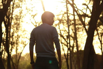 Rear view of man standing in forest