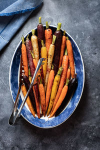 Top down view of an oval serving dish filled with roasted rainbow carrots.