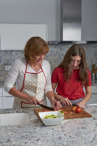 Mother and daughter standing at home