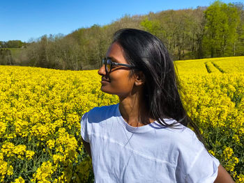 Woman looking away while standing on field