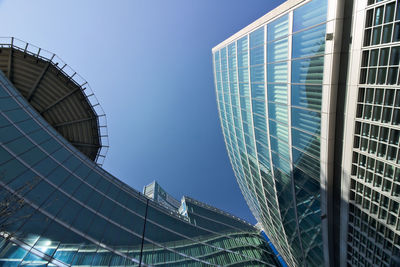 Low angle view of modern buildings against clear blue sky