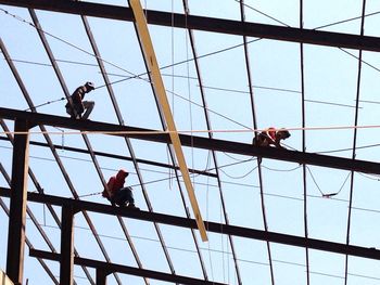 Low angle view of men working on construction frame