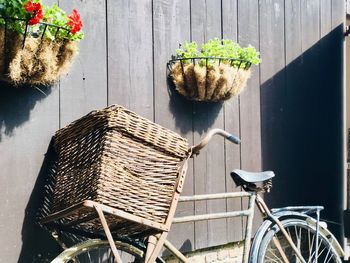 Potted plants in basket on table against wall