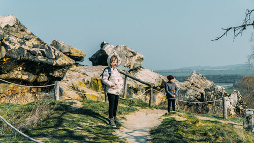 Panoramic shot of people standing on rock against sky