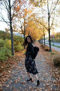 Full length portrait of woman standing in park during autumn
