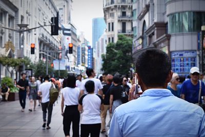 Rear view of people walking in city
