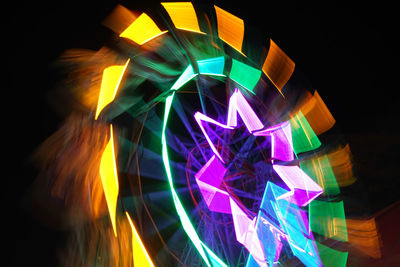 Close-up of illuminated lighting equipment against black background