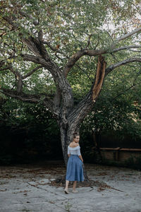 Full length of woman standing by tree