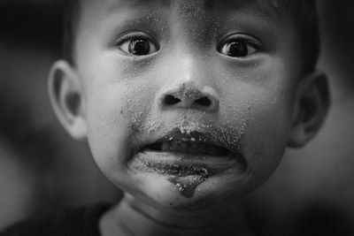 Close-up portrait of cute boy with dirty face