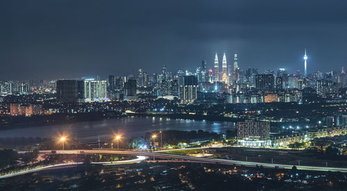 Illuminated buildings in city against sky at night