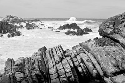 Scenic view of rocks in sea against sky