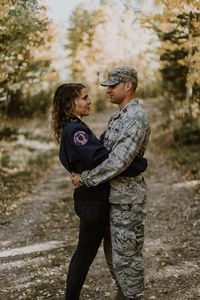 Full length of couple standing against trees