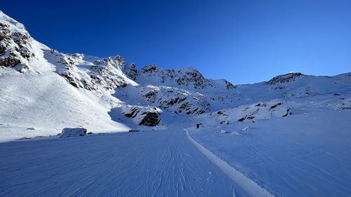 Scenic view of snowcapped mountains against clear sky