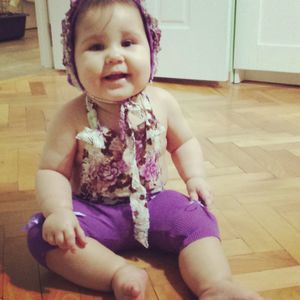 Cute baby girl sitting on hardwood floor