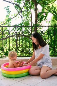 Mother and girl sitting on sofa