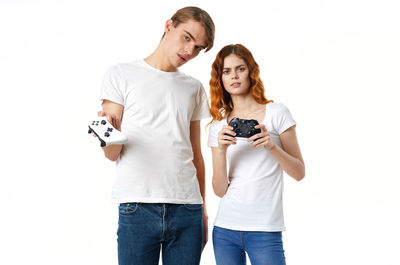 Full length of young woman standing against white background