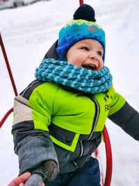 Portrait of smiling boy standing on snow
