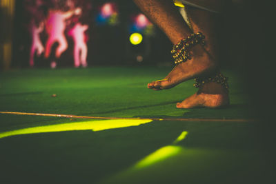 Low section of man playing with ball at night