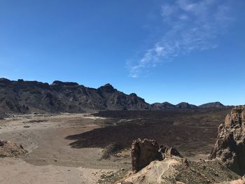 Scenic view of desert against blue sky