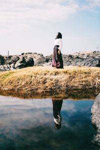 Man standing in lake against sky