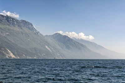 Scenic view of sea and snowcapped mountains against sky