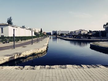 Bridge over river against buildings in city